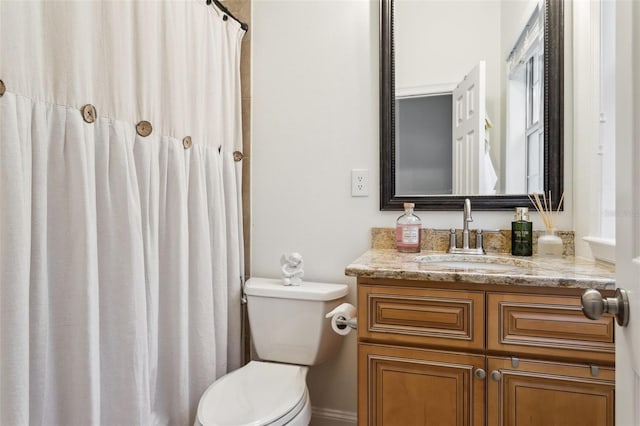 bathroom featuring toilet, vanity, and curtained shower