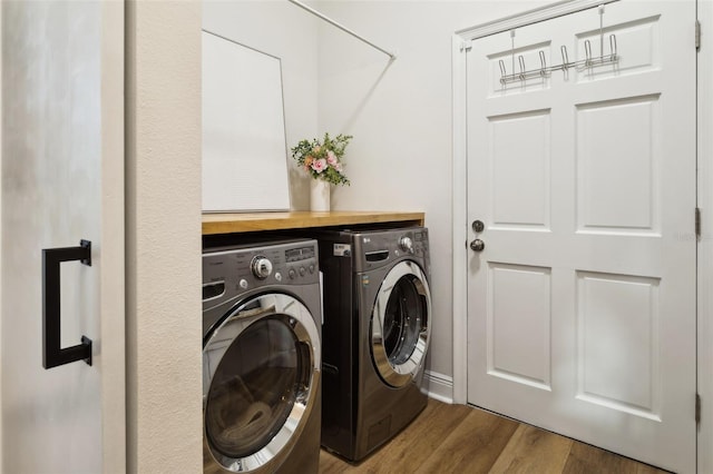 washroom featuring washer and clothes dryer and wood finished floors