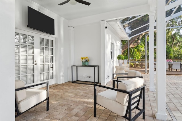 sitting room with a ceiling fan and brick flooring