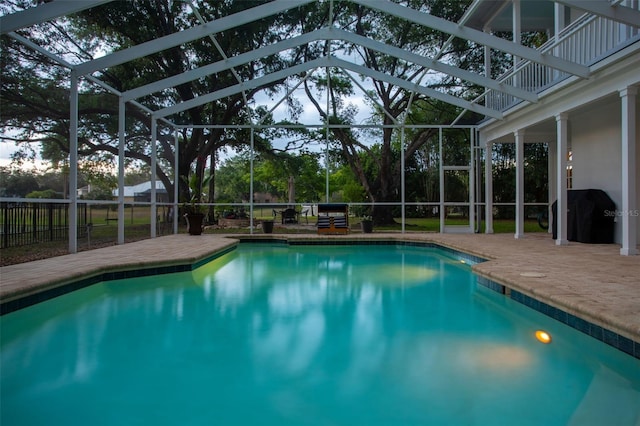 view of pool featuring glass enclosure, a patio area, and fence