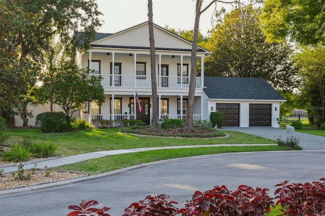 greek revival inspired property with a porch, an attached garage, a ceiling fan, driveway, and stucco siding