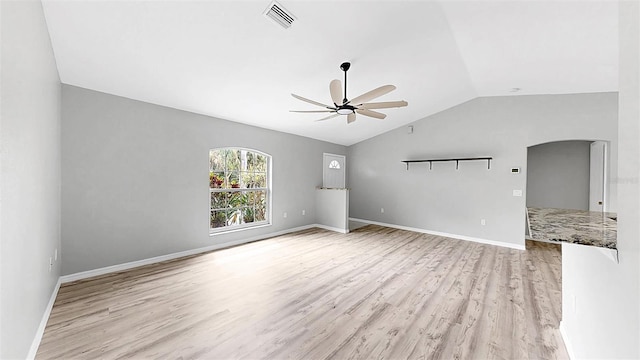 2675 Cherokee St, North Port, FL 34286 - unfurnished living room featuring a ceiling fan, vaulted ceiling, light wood finished floors, arched walkways, and baseboards