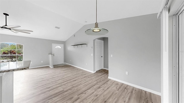 2675 Cherokee St, North Port, FL 34286 - unfurnished living room with a ceiling fan, light wood finished floors, vaulted ceiling, arched walkways, and baseboards