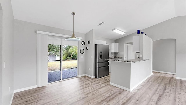 2675 Cherokee St, North Port, FL 34286 - kitchen with stainless steel fridge, lofted ceiling, white cabinets, light wood-style flooring, and baseboards