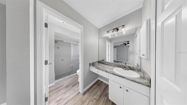 2675 Cherokee St, North Port, FL 34286 - bathroom featuring toilet, a stall shower, vanity, wood finished floors, and baseboards