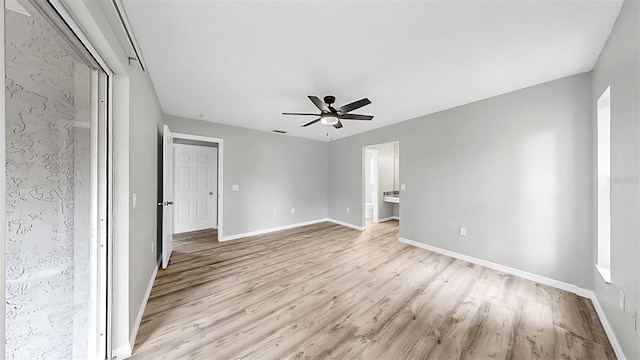 2675 Cherokee St, North Port, FL 34286 - unfurnished bedroom featuring light wood finished floors, baseboards, ceiling fan, and ensuite bath