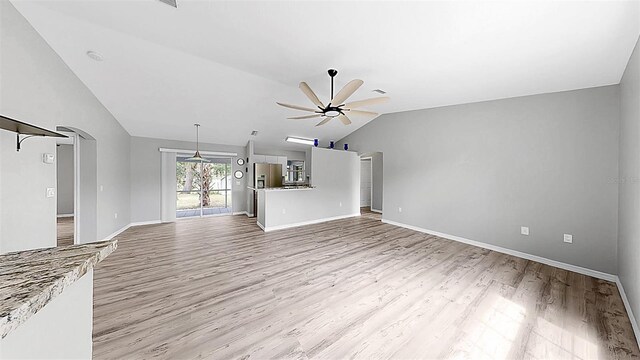 2675 Cherokee St, North Port, FL 34286 - unfurnished living room featuring lofted ceiling, a ceiling fan, light wood-type flooring, and baseboards