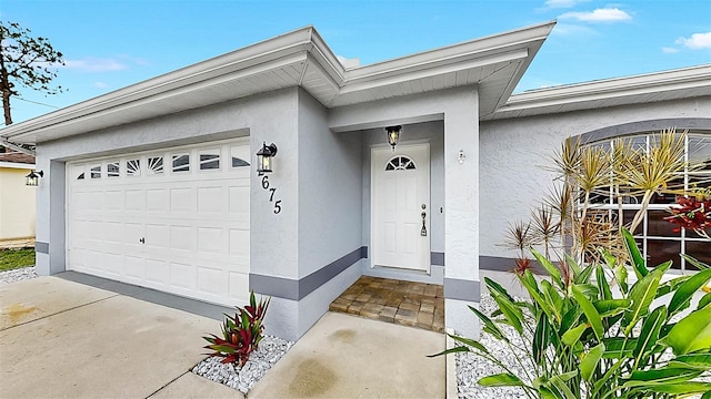 2675 Cherokee St, North Port, FL 34286 - property entrance featuring stucco siding, a garage, and driveway