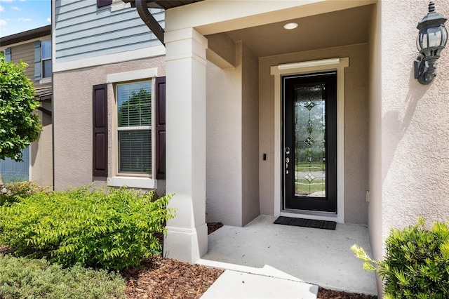 entrance to property featuring stucco siding