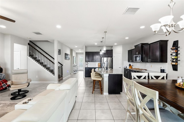 interior space featuring stainless steel appliances, a chandelier, visible vents, and open floor plan
