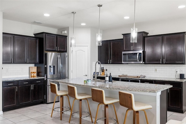 kitchen featuring a sink, stainless steel appliances, backsplash, and light tile patterned flooring