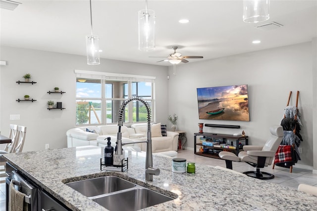 kitchen featuring a sink, open floor plan, pendant lighting, and visible vents
