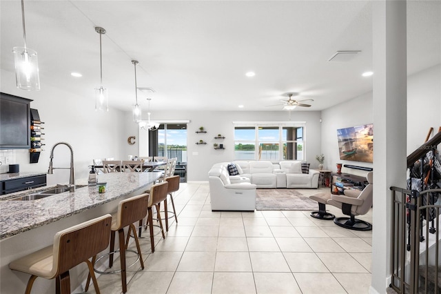 living room featuring light tile patterned floors, visible vents, ceiling fan, and recessed lighting