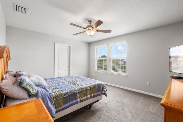 carpeted bedroom featuring visible vents, baseboards, and a ceiling fan