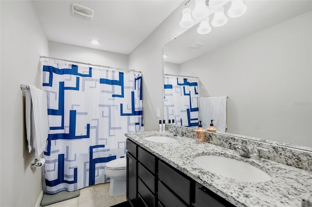 bathroom with double vanity, tile patterned floors, toilet, and a sink
