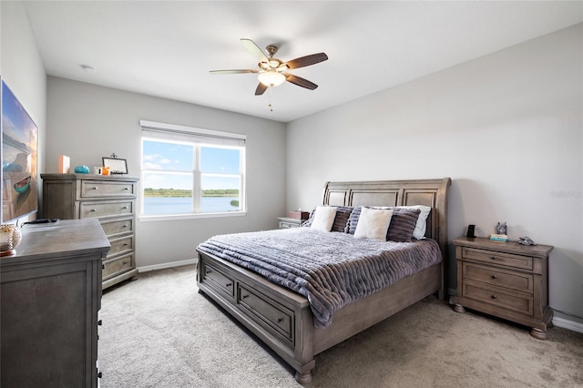 bedroom featuring light carpet, baseboards, and a ceiling fan