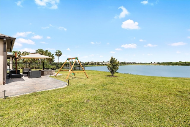 view of yard featuring a water view, a playground, fence, an outdoor hangout area, and a patio area
