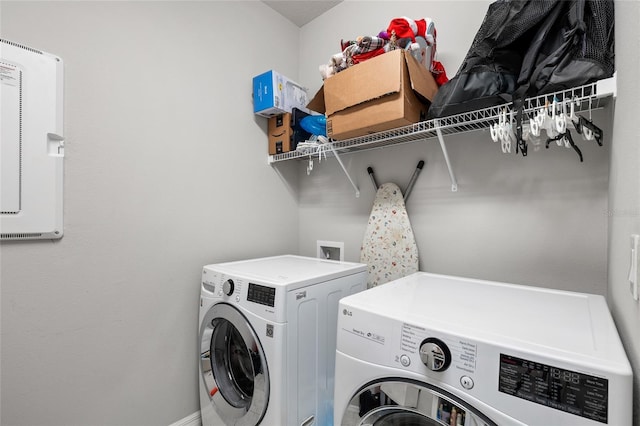 washroom with laundry area, baseboards, and washer and dryer