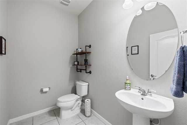 half bathroom with toilet, baseboards, visible vents, a sink, and tile patterned flooring