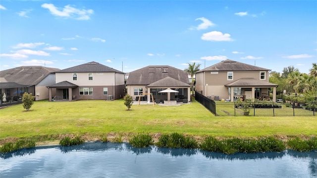 back of house with a gazebo, fence, central AC, a lawn, and a water view