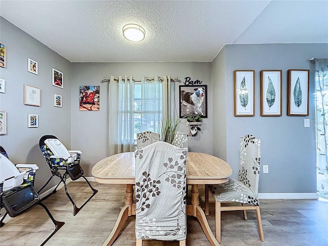 dining space featuring baseboards and a textured ceiling