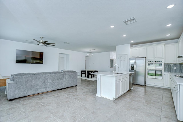 18657 Obregan Dr, Spring Hill, FL 34610 - kitchen with a sink, stainless steel appliances, light countertops, open floor plan, and decorative backsplash