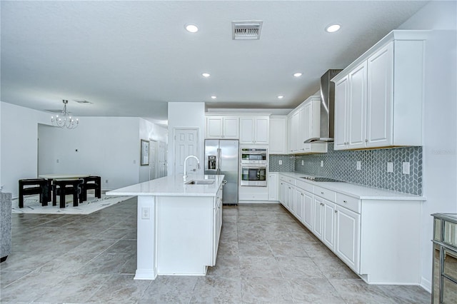 18657 Obregan Dr, Spring Hill, FL 34610 - kitchen featuring wall chimney range hood, appliances with stainless steel finishes, a sink, a chandelier, and decorative backsplash