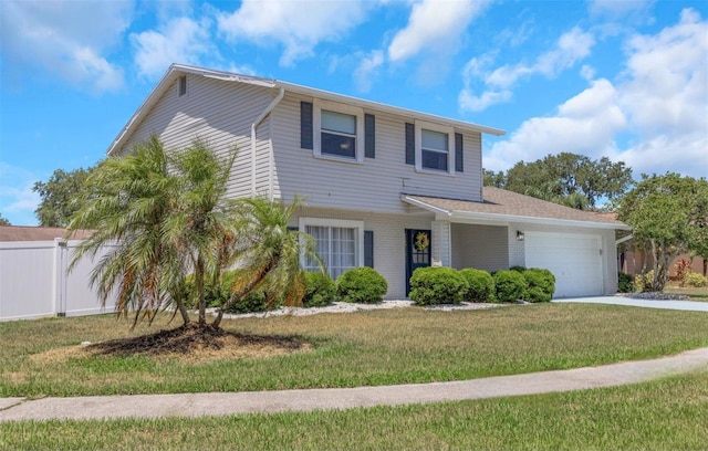 traditional-style house featuring fence, a garage, a front lawn, and concrete driveway