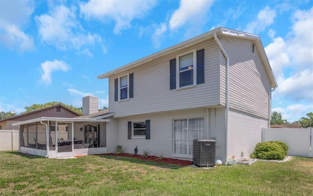 rear view of house featuring cooling unit, a sunroom, fence, and a yard