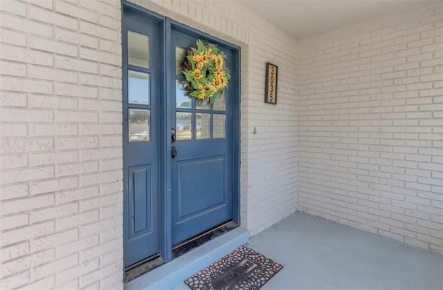doorway to property featuring brick siding