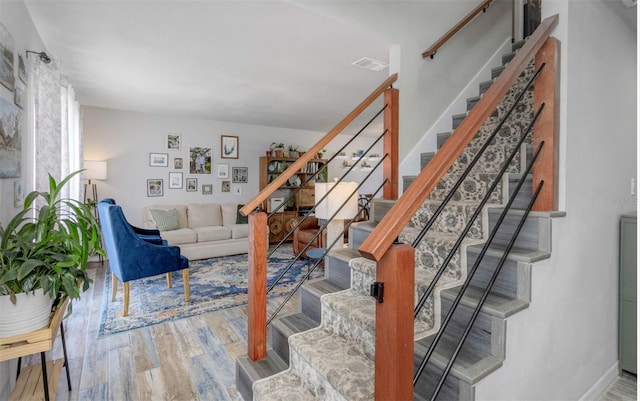 stairs featuring baseboards, visible vents, and wood finished floors
