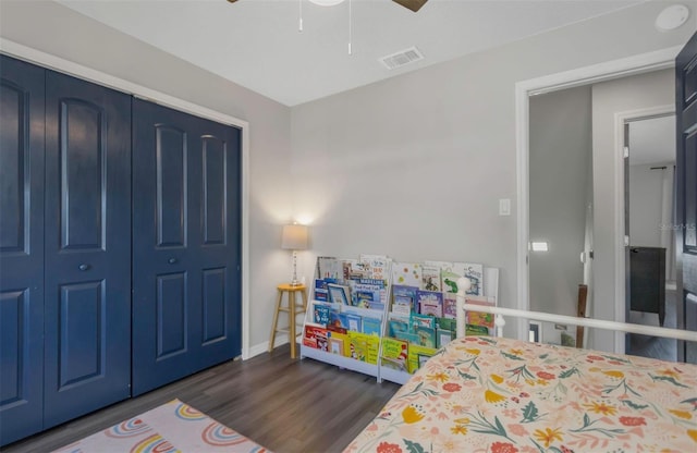 bedroom featuring a closet, visible vents, dark wood-style flooring, a ceiling fan, and baseboards