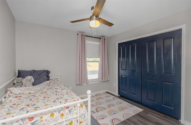 bedroom with baseboards, a closet, ceiling fan, and wood finished floors