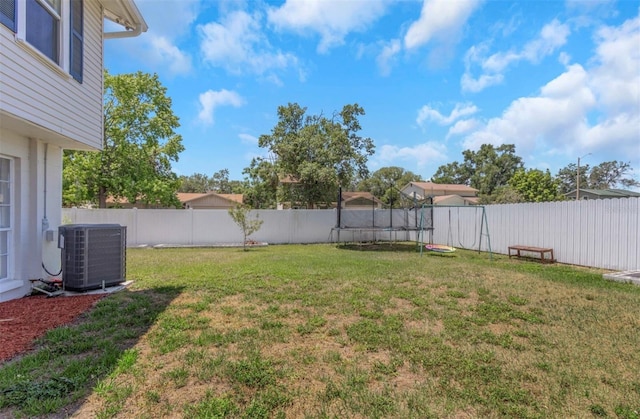 view of yard with a fenced backyard and central AC