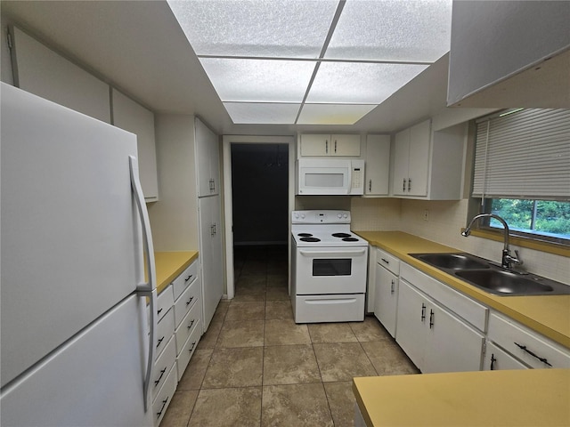 kitchen with a sink, white cabinetry, white appliances, light countertops, and tasteful backsplash