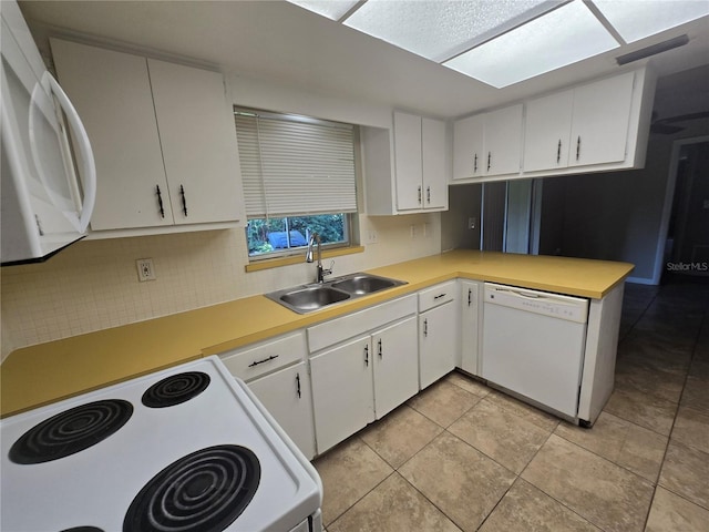 kitchen with backsplash, light countertops, a sink, and white appliances