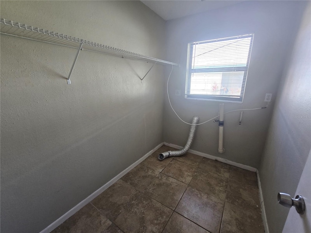 laundry room with laundry area, baseboards, and tile patterned floors
