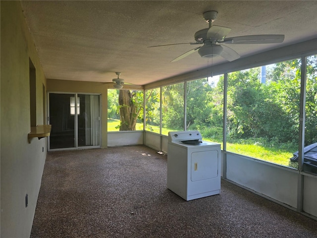 unfurnished sunroom with a ceiling fan and washer / dryer