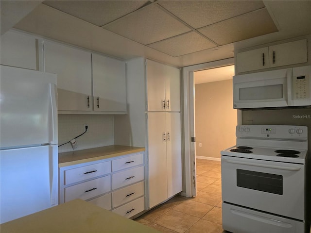 kitchen featuring white appliances, light countertops, light tile patterned floors, and white cabinets