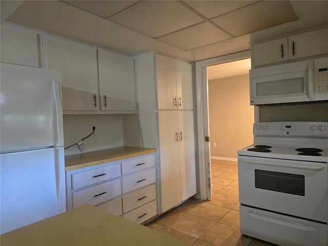 kitchen with white cabinets, light countertops, light tile patterned floors, and white appliances