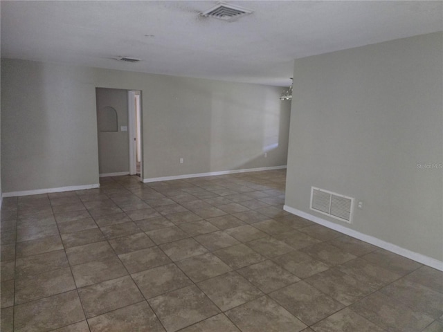 unfurnished room with baseboards, tile patterned flooring, a chandelier, and visible vents