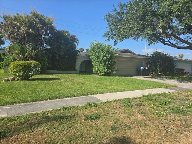 view of yard featuring an attached garage and driveway