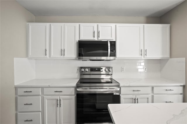 11323 Ivy Flower Loop, Riverview, FL 33578 - kitchen featuring appliances with stainless steel finishes, decorative backsplash, light stone counters, and white cabinetry