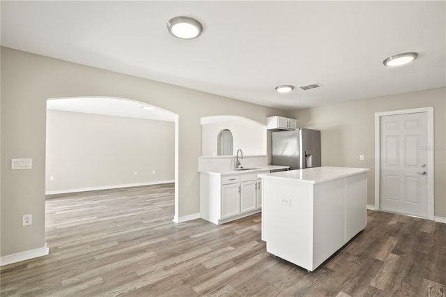 11323 Ivy Flower Loop, Riverview, FL 33578 - kitchen featuring stainless steel fridge, wood finished floors, a sink, arched walkways, and light countertops