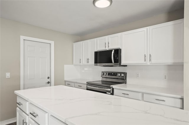 11323 Ivy Flower Loop, Riverview, FL 33578 - kitchen with light stone countertops, stainless steel appliances, tasteful backsplash, and white cabinets