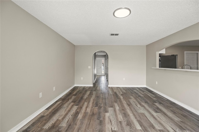 11323 Ivy Flower Loop, Riverview, FL 33578 - spare room with dark wood finished floors, visible vents, baseboards, a textured ceiling, and arched walkways