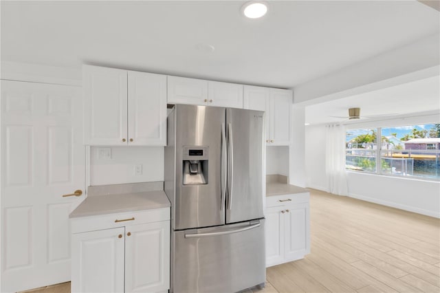 13612 Veronica Dr, Hudson, FL 34667 - kitchen featuring stainless steel fridge, light countertops, white cabinets, light wood-style floors, and recessed lighting