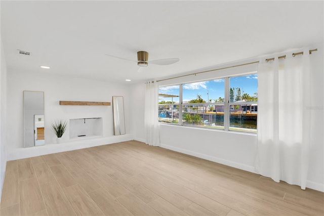 13612 Veronica Dr, Hudson, FL 34667 - unfurnished living room featuring light wood finished floors, a ceiling fan, recessed lighting, baseboards, and a water view