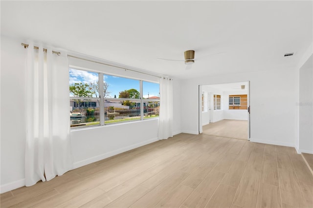 13612 Veronica Dr, Hudson, FL 34667 - spare room featuring light wood-style flooring, ceiling fan, and baseboards