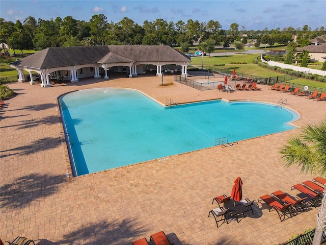 community pool with fence and a patio